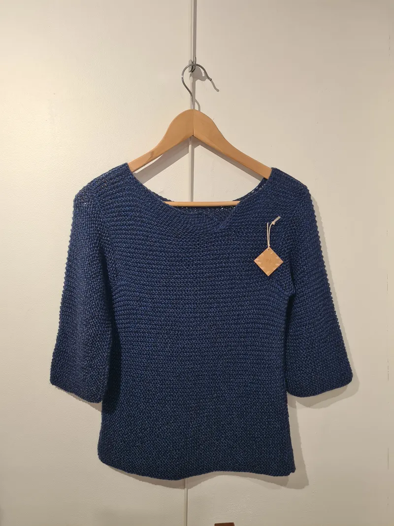 Étagère remplie de pelottes de laines de différentes couleurs